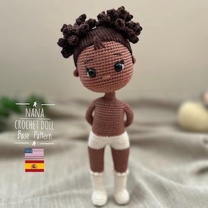 May include: A handmade crochet doll with dark brown skin, hair, and eyes. The doll is wearing white shorts and socks. The text "NANA CROCHET DOLL Base Pattern" is displayed with the American and Spanish flags.