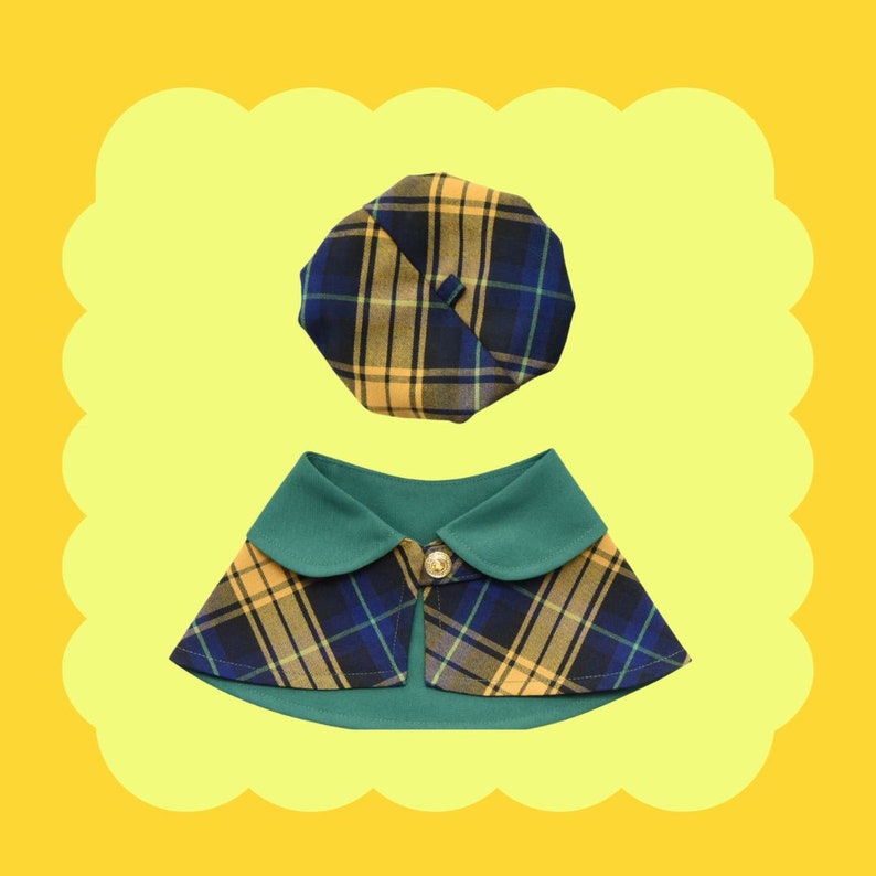 May include: A plaid dog collar with a matching plaid beret. The collar is green with yellow and blue plaid, and the beret is yellow with blue and green plaid.