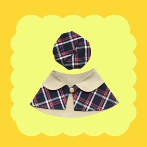 May include: A plaid fabric dog collar with a matching plaid fabric hat. The collar has a beige trim and a button closure.