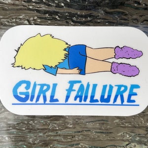 Puede incluir: Una pegatina blanca con una ilustración de dibujos animados de una persona con cabello rubio acostada boca abajo con las piernas en el aire. La persona lleva pantalones cortos azules y calcetines peludos morados. El texto "GIRL FAILURE" está escrito en letras azules debajo de la ilustración.