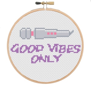 May include: A white embroidery hoop with a purple cross-stitch design of a microphone and the text "Good Vibes Only".