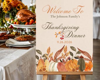 May include: A rectangular welcome sign on a wooden easel featuring the text Welcome To The Johnson Family's Thanksgiving Dinner 11.26.2026. The design includes watercolor illustrations of pumpkins, gourds, and autumn leaves in orange and brown.