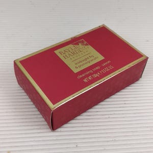 May include: A rectangular box of Baylis & Harding cleansing soap in a deep red color with gold trim. The label reads "midnight fig & pomegranate" and "NET WT 3.5 OZ US."
