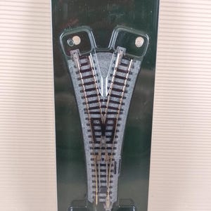 May include: A KATO UNITRACK #2 Electric Wye Turnout model train track in N-gauge. The track is packaged in a clear plastic blister pack with a green background. The package includes the track, a small electrical component, and a red and black wire.