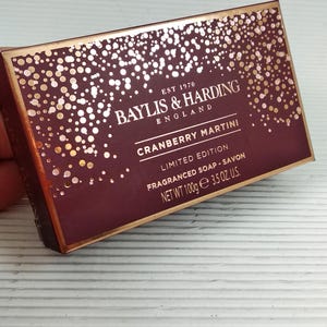 May include: A rectangular box of Baylis & Harding Cranberry Martini fragranced soap. The box is burgundy with gold accents and text, including "Limited Edition" and "Net Wt 3.5 OZ. U.S."