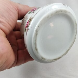 May include: White ceramic container with a floral design featuring pink and red roses. The container has a rounded shape and a slightly flared rim. The bottom of the container is plain white. The date and time 2025/4/27 00:41 are visible.