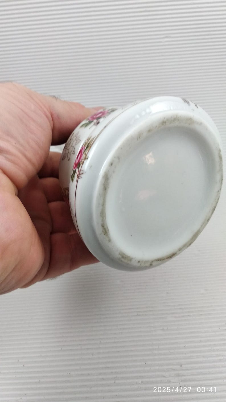 May include: White ceramic container with a floral design featuring pink and red roses. The container has a rounded shape and a slightly flared rim. The bottom of the container is plain white. The date and time 2025/4/27 00:41 are visible.