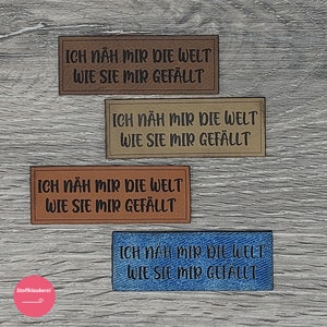 Könnte beinhalten: Vier Stoffpatches mit dem Text "ICH NÄH MIR DIE WELT WIE SIE MIR GEFÄLLT" in schwarzer Schrift. Die Patches sind in verschiedenen Farben und Texturen: braun, beige, braun und blau.