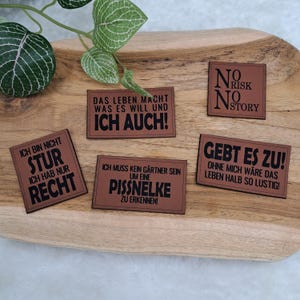 Könnte beinhalten: Ein Set aus drei Keramikbechern mit gesprenkelter, matter Oberfläche. Die Becher sind in Creme-, Hellgrau- und Dunkelgrautönen gehalten. Jeder Becher hat ein schlichtes, minimalistisches Design.