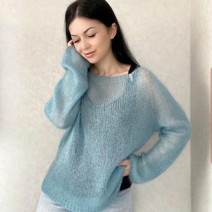 May include: A light blue, sheer knit sweater with a loose fit and long sleeves.