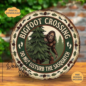 May include: Round metal sign with a Bigfoot illustration peeking from behind a tree. The sign reads "Bigfoot Crossing" and "Do Not Disturb the Sasquatch" in a circular design with pinecones and footprints.