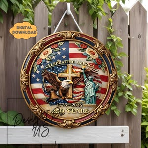 May include: A round wooden sign with a patriotic theme. The sign features the American flag, an eagle, the Statue of Liberty, and the text "Celebrating America 1776-2026 250 Years." The sign has a decorative gold border and is hanging on a wooden fence.