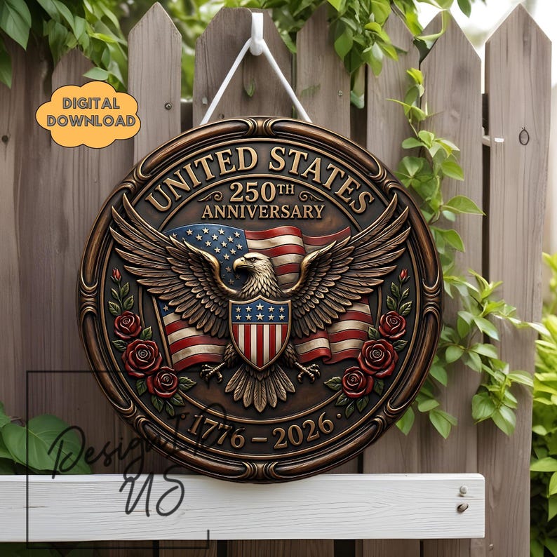 May include: A circular, bronze-toned sign celebrating the 250th anniversary of the United States. It displays an eagle, the American flag, and the inscription "UNITED STATES 250TH ANNIVERSARY 1776-2026". The design also incorporates red roses.