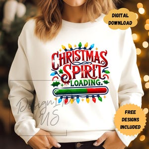 May include: White sweatshirt with a Christmas spirit loading graphic. The graphic features a progress bar with a red and green bar, and the text "Christmas Spirit Loading." The graphic is surrounded by colorful Christmas lights.