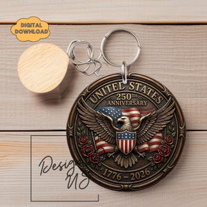 May include: A bronze-coloured keychain featuring an eagle with outstretched wings, the American flag, and roses. The text "UNITED STATES 250TH ANNIVERSARY 1776-2026" is displayed. A wooden disc and a metal keyring are also visible.