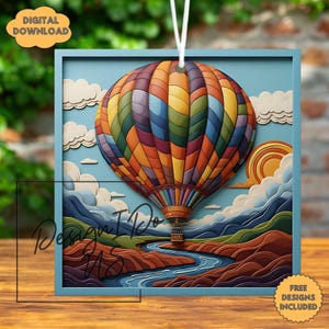 May include: A colorful hot air balloon illustration with a blue frame, a river, and mountains. The balloon is filled with various colors. The image includes the text "DIGITAL DOWNLOAD" and "FREE DESIGNS INCLUDED".