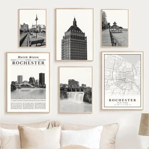 May include: A collection of framed black and white prints featuring Rochester, New York. The prints depict cityscapes, architecture, a map, and a waterfall. The Kodak building is prominently displayed in one print.