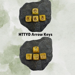 May include: Two sets of yellow, square arrow keys with etched designs, arranged on dark grey stones. The text "HTTYD Arrow Keys" is displayed below the keys. The keys have a weathered appearance, with brown etched symbols.