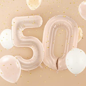 Large beige number balloons forming 50, neutral milestone decoration for a 50th birthday party