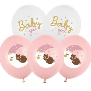 May include: Set of six pink and white balloons with a baby girl theme. The pink balloons have a sleeping bear on a crescent moon with stars. The white balloons have the text "Baby girl" in gold lettering.