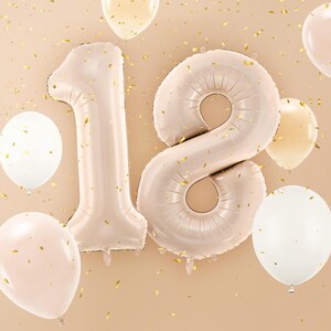 Large beige number balloons forming 18, elegant neutral decoration for an 18th birthday celebration