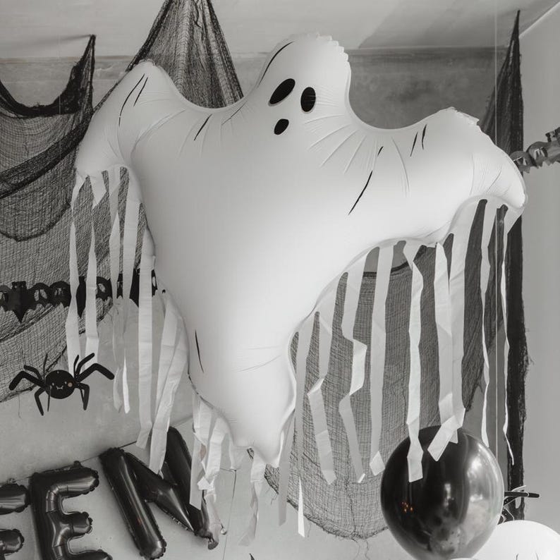 Close up of large white ghost balloon with flowing tassels in a spooky Halloween display