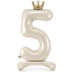 May include: A large, white, number 5 balloon with a gold crown on top. The balloon is standing upright on a white base.