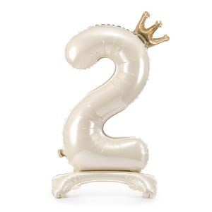 Shiny cream foil balloon shaped like the number two with a small gold crown on top, standing upright on a white background.