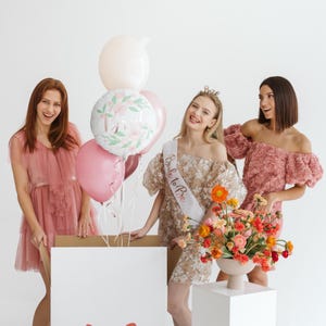 bridal shower party with bride balloon, bachelorette party decorations, women celebrating with pastel balloons and floral decor