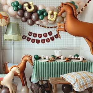 Brown horse foil balloon decorating a cowboy themed party table with western style decorations