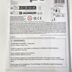 May include: A warning label for a foil balloon. The label is printed in English and several other languages. The label warns about choking hazards and the importance of adult supervision when using balloons. It also warns about the dangers of plastic bags and the need to keep them away from children.
