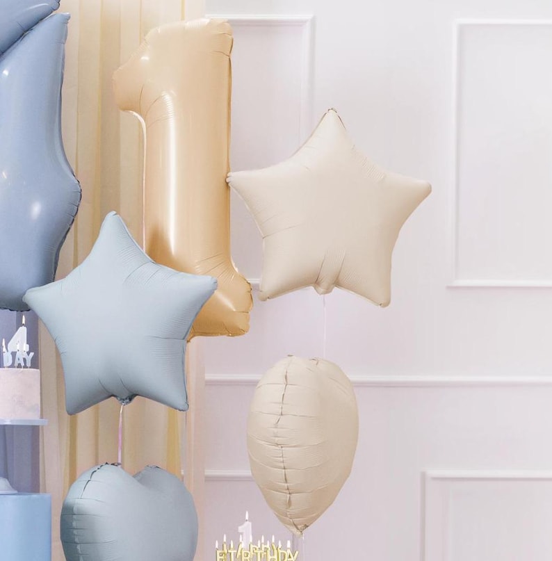 Puede incluir: Un conjunto de globos de aluminio dorados y azules para una fiesta de primer cumplea&ntilde;os. Los globos incluyen un gran n&uacute;mero uno, una estrella y un coraz&oacute;n.