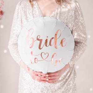 May include: White balloon with the text "bride to be" in rose gold lettering.