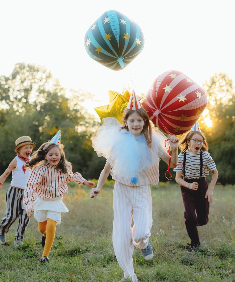 Red and pink striped foil balloon with gold star pattern – circus-themed party decoration, round helium balloon for birthday, carnival, or festive events