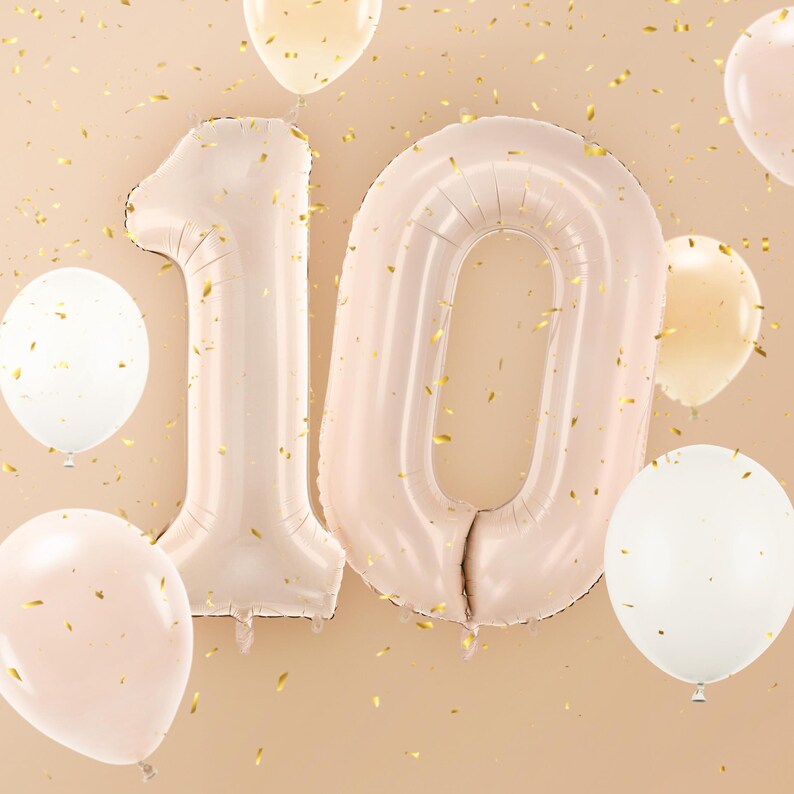 Large beige number balloons forming number 10, neutral birthday party decoration with white and gold balloons