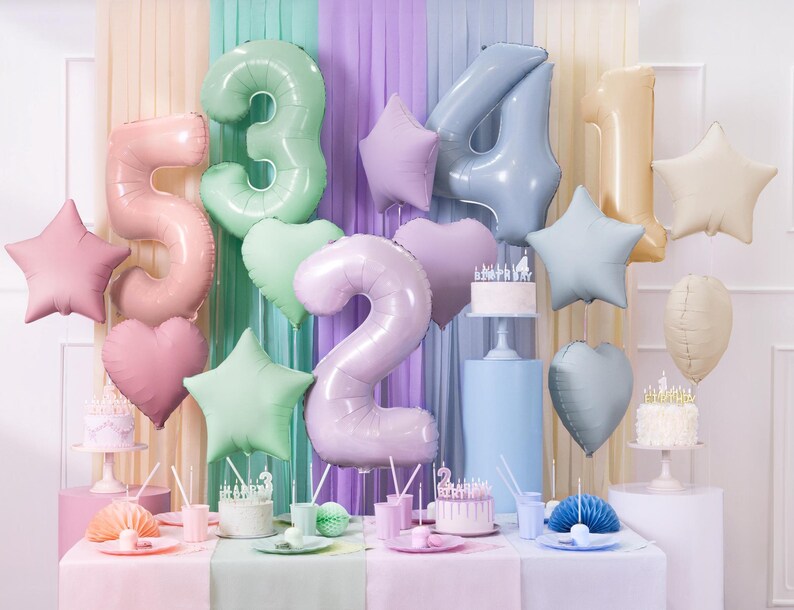 May include: A pastel-colored birthday party decoration set with foil balloons in the shape of numbers, stars, and hearts. The balloons are in shades of pink, blue, green, and gold.