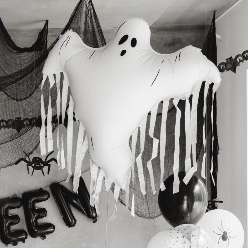 White Halloween ghost balloon with flowing tassels styled in a black and white spooky party display