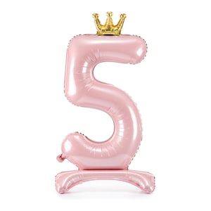 May include: A pink number 5 balloon with a gold crown on top. The balloon is standing upright on a base.