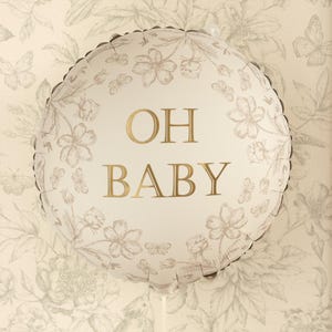 Puede incluir: Globo redondo blanco con texto dorado "OH BABY". El globo est&aacute; decorado con patrones florales y de mariposas en un color neutro. Es una decoraci&oacute;n para una fiesta de bienvenida al beb&eacute; o de revelaci&oacute;n de g&eacute;nero.