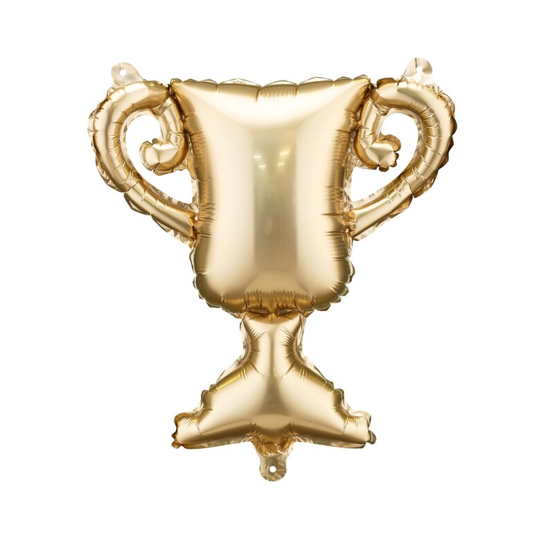 May include: A gold-colored trophy-shaped balloon. The balloon has a classic trophy design with a wide cup, two curved handles, and a pedestal base. The balloon is inflated and ready for a celebration.