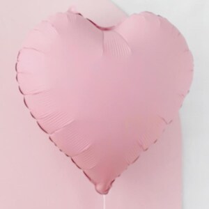 May include: A light pink heart-shaped balloon.