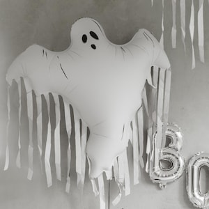Large ghost balloon with long hanging tassels creating a floating Halloween decoration