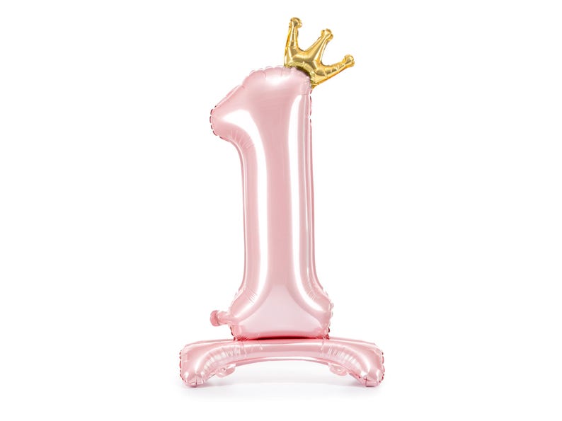 May include: A pink number one balloon with a gold crown on top. The balloon is standing on a pink base.