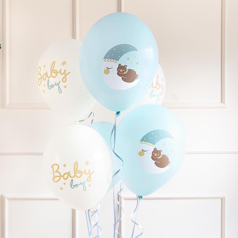 Puede incluir: Un conjunto de globos azules y blancos con tem&aacute;tica de beb&eacute;. Los globos tienen un dise&ntilde;o de luna y oso y el texto "Baby boy" impreso en ellos.