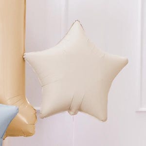 Puede incluir: Un globo de estrella de color crema hecho de papel de aluminio.
