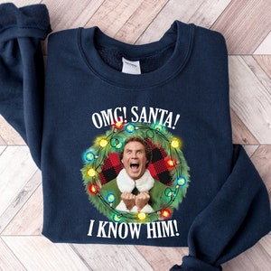 OMG サンタ、彼を知っているシャツ、面白いシャツ、ビンテージ クリスマス スウェットシャツ、エルフ シャツ、クリスマス シャツ、サンタ シャツ、ホリデー ムービー シャツ、ギフト T シャツ