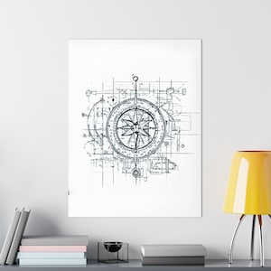 May include: A black and white print of a compass rose, centered on a white background. The compass is surrounded by a blueprint-style design. The print is displayed on a wall above a shelf with books and a decorative lamp.