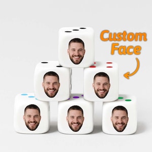 May include: Six white dice with a custom face printed on each side, stacked in a pyramid shape. Each die features a different number of black dots and a smiling man's face. The words "Custom Face" are in orange.