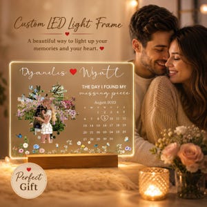 May include: A rectangular LED light frame with a wooden base featuring the names Dyanelis and Wyatt, a puzzle-shaped photo of a couple, the text The day I found my missing piece, and a calendar for August 2023 with a heart around the number 9.