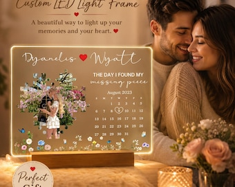 May include: A rectangular LED light frame with a wooden base featuring the names Dyanelis and Wyatt, a puzzle-shaped photo of a couple, the text The day I found my missing piece, and a calendar for August 2023 with a heart around the number 9.
